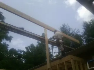Carpenter setting a ridge beam over a new addition frame — Ice Dam Removal by Roofing Brothers in Vergennes