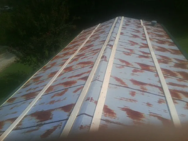 Rusted metal roof panels with new wood purlins before replacement — Storm Damage Roof Repair in Vergennes by Roofing Brothers
