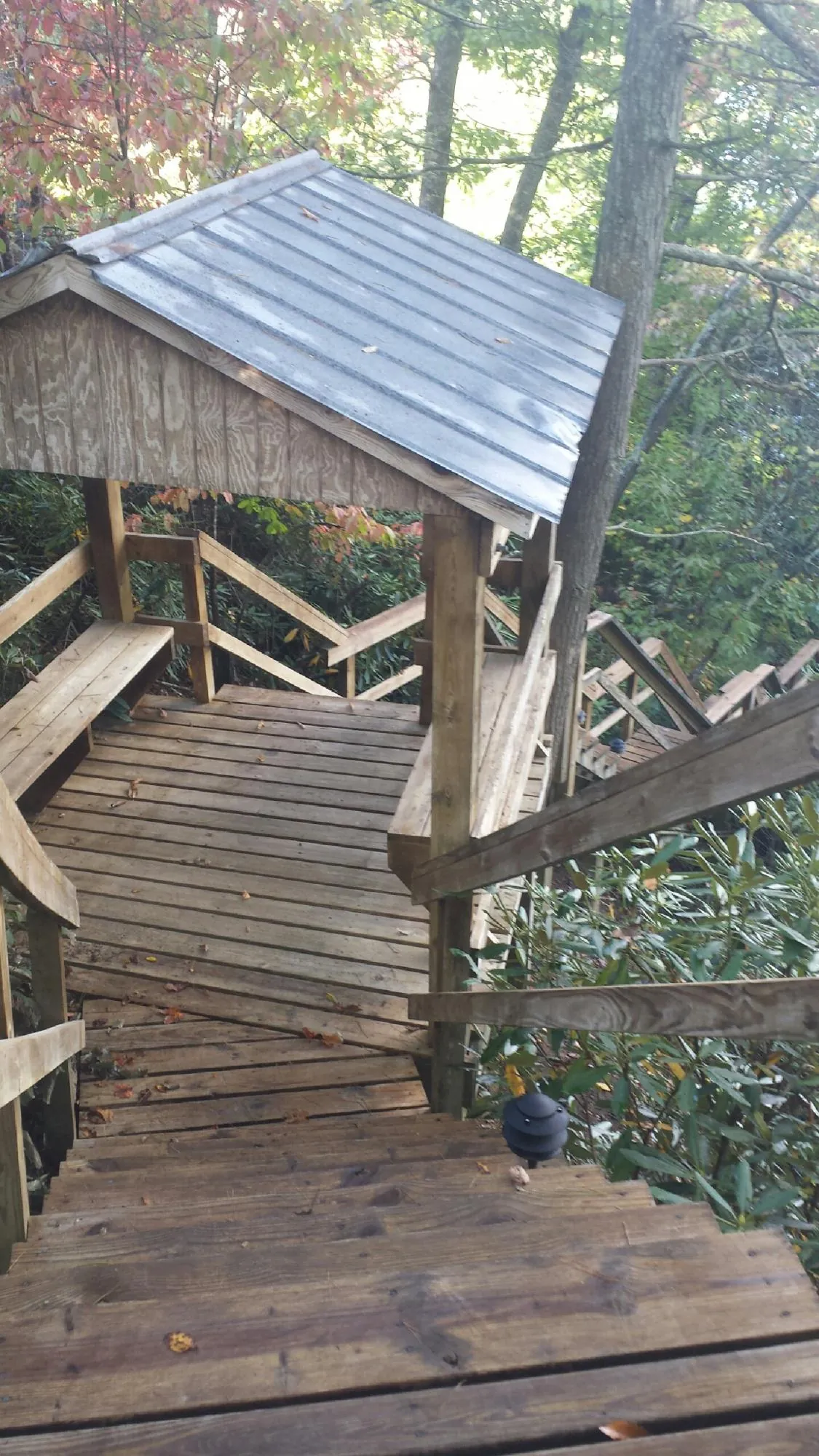 Metal roofed shelter over wooden steps on a wooded walkway — Skylight Repair & Installation work by our crew in Vergennes