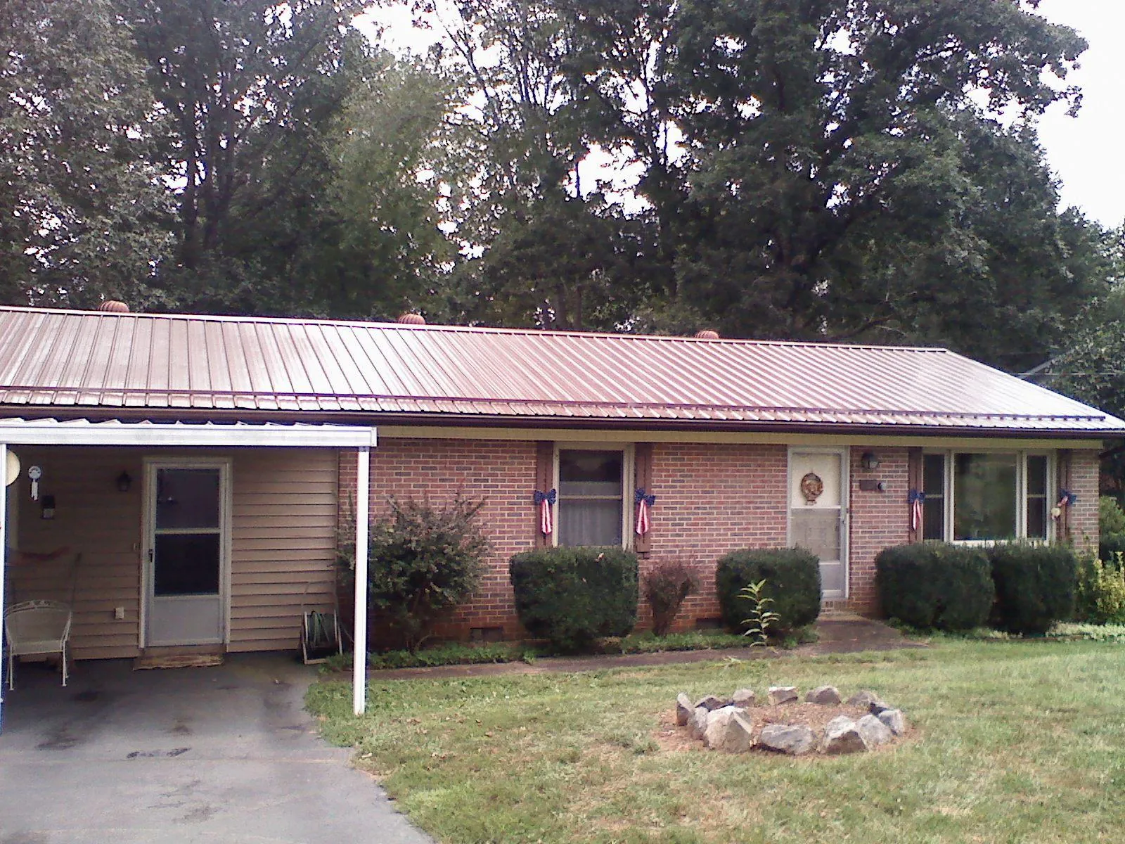 Bronze metal roof and carport on a brick ranch home — Roof Repair work by our crew in Vergennes